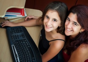 Hispanic mother and her daughter working on a computer