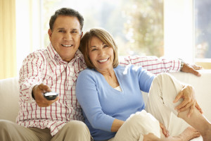 Senior Hispanic Couple Watching TV At Home