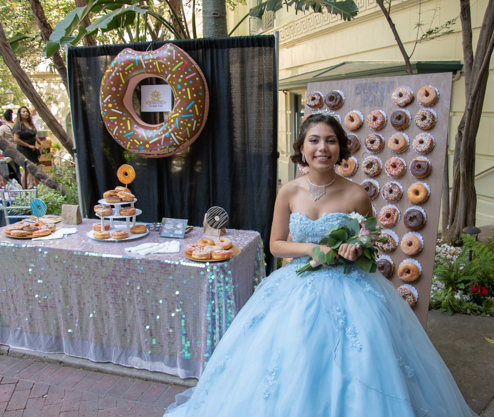 Quinceañera smiling next to a donut decorations