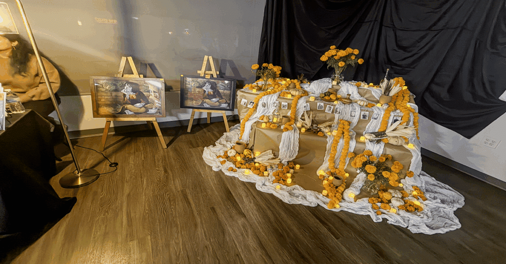Altar de Día de los Muertos con velas, flores de cempasúchil y ofrendas en la celebración organizada por El Clasificado en Los Angeles.